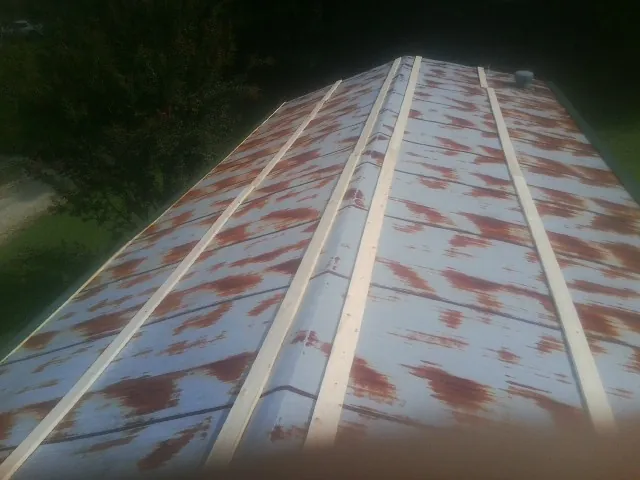 Rusted metal roof panels with new wood purlins before replacement — Storm Damage Roof Repair in Gate City by Roofing Brothers