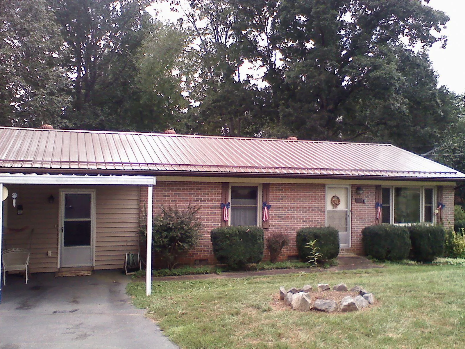 Bronze metal roof and carport on a brick ranch home — Roof Repair work by our crew in Gate City